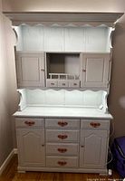 Front view of vintage lavender distressed kitchen hutch with closed cabinets and drawers