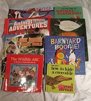 Top view showing all 8 books in the lot arranged in 2 rows on a white surface; titles and covers visible for identification