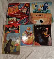 Top view of the assortment of Disney Pixar books showing titles including The Incredibles, Toy Story 3, Brave, WALL-E, and a read-aloud collection.