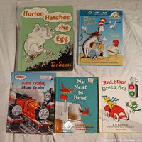 Four children's books including Dr. Seuss 'Horton Hatches the Egg', 'Cat in the Hat at the Beach', 'Fast Train, Slow Train', 'My Nest Is Best' and 'Red, Stop! Green, Go!'