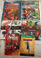Lot of seven Marvel kids books including sticker book, joke book, story collections, and reading level book.