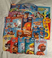 Full lot of Paw Patrol board books with colorful covers, including a sound book with buttons and a booklet with an activity section.