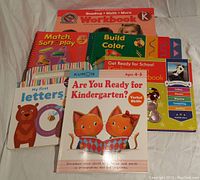 Lot of 7 assorted colorful pre-K workbooks including one missing dry erase marker and some with filled pages