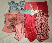 Photo of assorted girls size 5 shirts, bodysuit, leggings, and dress with various patterns including food graphics and ruffles.
