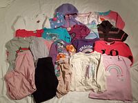 Overview of assorted girls size 5 clothing including tops, leggings, and sweaters in various colors and designs.
