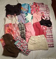 Full clothes lot spread out showing all clothing items included in the lot