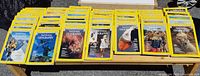 Wide view of 34 National Geographic magazines laid out flat showing the yellow borders and various cover images from the 1970s.