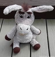Front view of gray Donkey plush toy with ears extended and facial details, showing soft fabric texture and brown hooves.