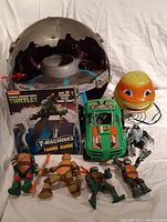 Front view of the TMNT lot showing figures, lamp, vehicle, Technodrome dome and T-Machines Turbo Guide