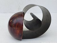 Side view of the metal and wood letter holder showing the curved metal structure and rounded wooden accent.