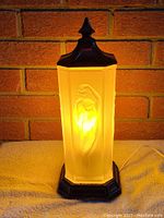 Front view of lamp illuminated against brick background