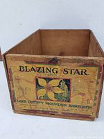 Front and back views of the wooden crate showing the Blazing Star brand label and condition.