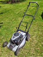 Photo of Briggs & Stratton 550EX CanadianMade Elite lawn mower on grass, front angled view showing engine, handlebar and wheels.