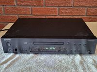 Front view of Onkyo CD player in black metal enclosure showing front panel and controls.