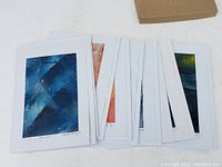 Lot of multiple vintage hand painted greeting cards stacked with visible abstract colorful designs and white border.