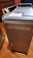 Front view of the Apple Mac Pro G5 tower showing the perforated aluminum panel and partial carry handle on top.
