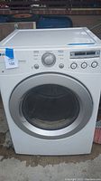 Front view of LG white front loading dryer with circular door and control panel visible.