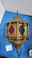 Front view of the Moroccan lantern showing red, green, and decorative pierced metal body