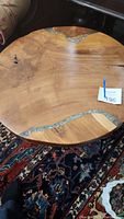 Top view of round wood table with visible natural knots and acrylic river inlays.