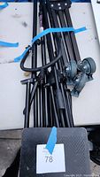 Fold-up tripod dolly with lockable caster wheels and carrying handle, partially folded and resting on table