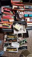 Overhead view of assorted Tyco HO scale trains in original boxes, power controllers, scenery accessories