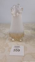Front view of antique turkey footed glass vase showing frosted white body and clear textured foot base