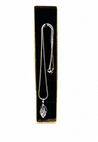 Full view of the necklace displayed in a black velvet-lined gold-colored box showing the pendant and chain neatly resting inside.