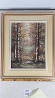 Framed oil painting with forest interior scene.