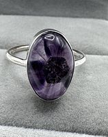 Front view showing the oval variegated amethyst cabochon with visible internal color variations and translucent purple hues.