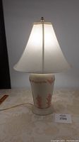 Vintage table lamp illuminated showing the overall look and style, including the base and shade.