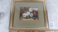 Full shot of the framed watercolour painting showing the floral still life with a measuring ruler beneath for scale.