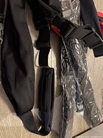 Photo showing black fabric money belts with adjustable straps, some still in plastic packaging.