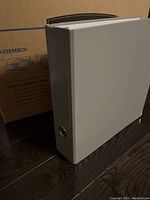 Single upright binder leaning against box with product instructions visible on box