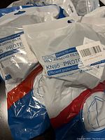 Ten sealed retail packs of KN95 five-layer disposable face masks in blue, red, white packaging shown together on a surface.
