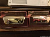 Two boxed Matchbox Models of Yesteryear diecast vehicles displayed side by side showing the 1945 MG TC and 1920 Rolls Royce Fire Engine.