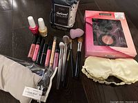 Full lot with cosmetics, brushes, wipes, eye pillow, and mask laid out on floor.