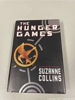 Front cover of The Hunger Games hardcover first edition by Suzanne Collins with dust jacket showing the title and emblem.