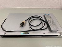 Top view of LG DVD player showing power cord wrapped and resting on device surface.