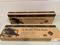 Two sealed rectangular cardboard boxes labeled 'RTA Traditional 15 Bottle Wine Rack'. Each box shows an image of the wooden wine rack and details about easy assembly and bottle capacity.