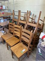 Group photo of stacked and arranged oak ladder back dining chairs showing overall condition and style