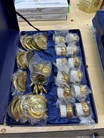 Full set of espresso cups and saucers in blue lined storage case with items individually wrapped in plastic for protection.