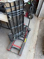 Hydraulic lift positioned vertically for storage, showing underside and frame detail.