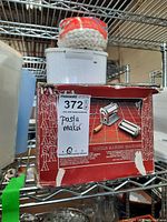 Pasta maker in worn red and white box with label showing model and function.