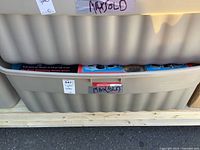 Large grey plastic storage bin containing board games and puzzles