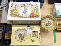 Top view of boxed Wedgwood Peter Rabbit Nursery Set and Royal Doulton Bunnykins sets with the bowl and cup visible inside the box.