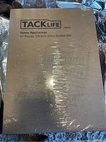 Front side of boxed set showing brand Tacklife and title '47 Pieces 3/8-Inch Drive Socket Set'. Box is shrink-wrap sealed.