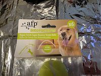 Front view of the product package featuring a golden retriever and product information for the AFP Hyper Fetch Super Bounce Tennis Balls, showing the 6 pack.