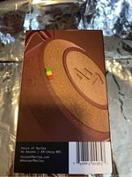 Photo of the front side of the box showing the image and branding for the House of Marley No Bounds Bluetooth speaker in red with details on materials and eco-friendliness.