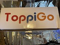 Photo of the Toppigo branded box showing the product name and logo