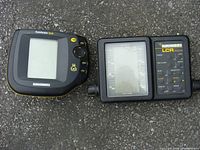Photo showing two fish finder units side by side on a grey surface. The left unit is the Humminbird Fishfinder 515 with a square screen and yellow and black casing. The right unit is the Humminbird LCR 3004 with a large depth range display and control panel.